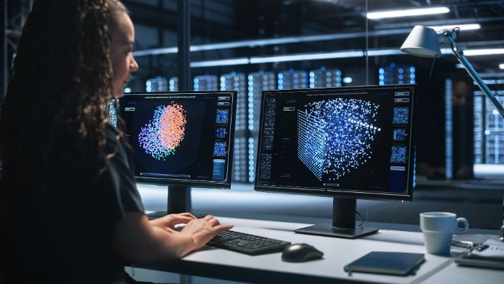Frau vor Bildschirmen in einem Serverkontrollraum © Gorodenkoff - Adobe Stock