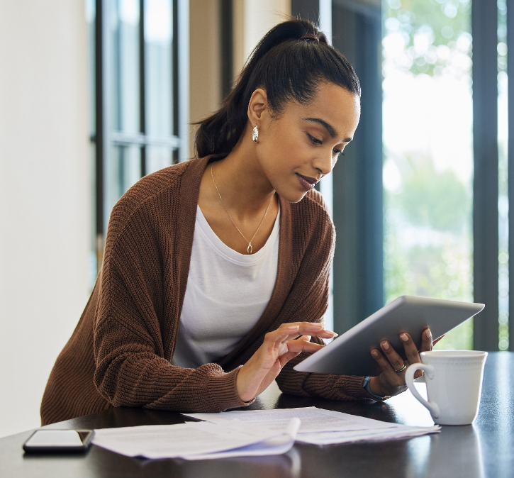 Junge Frau sitzt am Schreibtisch mit Tablet in der Hand © CineLens_peopleimages_com - AdobeStock
