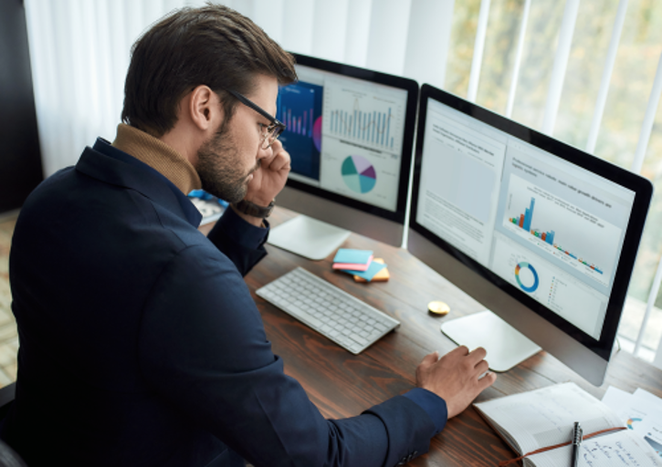 Mann sitzt vor Computer. Auf dem Computerbildschirm sind Tabellen und Grafiken geöffnet. © Svitlana - AdobeStock