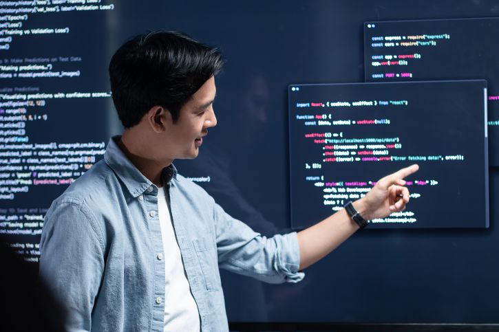 Asiatischer Mann wertet Code aus der zuvor mit KI generiert wurde &copy; SAT65  - Adobe Stock 