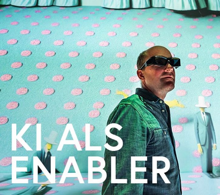 Mann steht mit Virtual Reality Brille. Hintergrund ist eine bunte Wand mit Punkten und grafischen Elementen. Text im Bild: KI als Enabler: © Philipp Greindl - APA