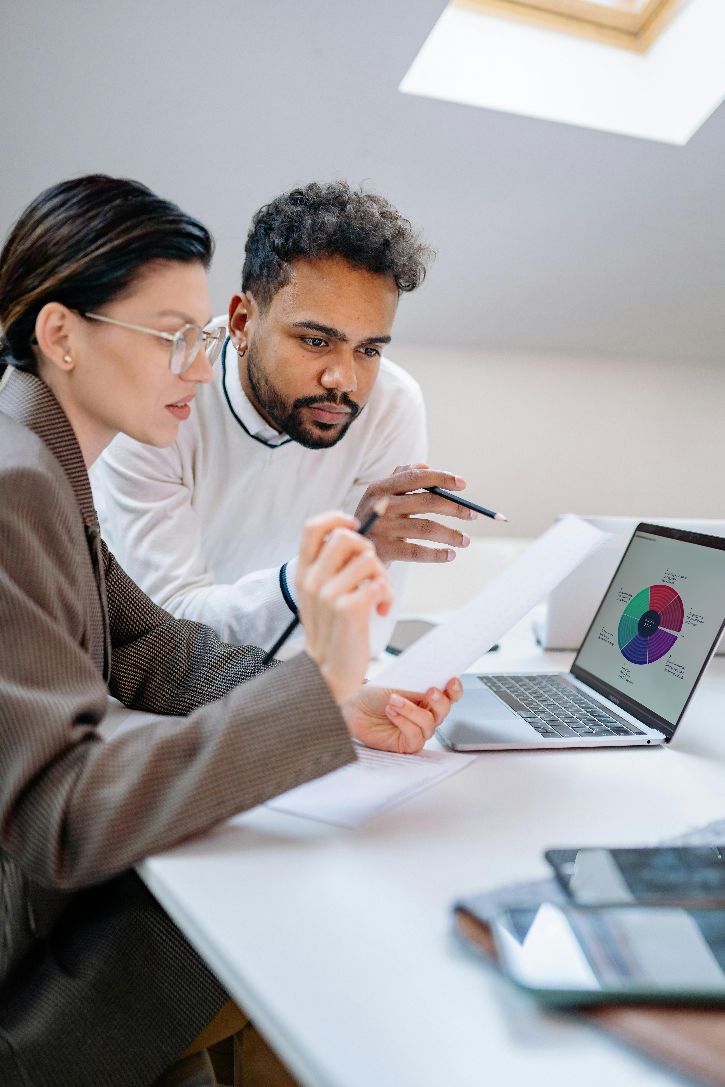 Zwei Personen vor einem Laptop. Auf dem Bildschirm des Laptops eine Grafik des DigComp. &copy;  pexels 