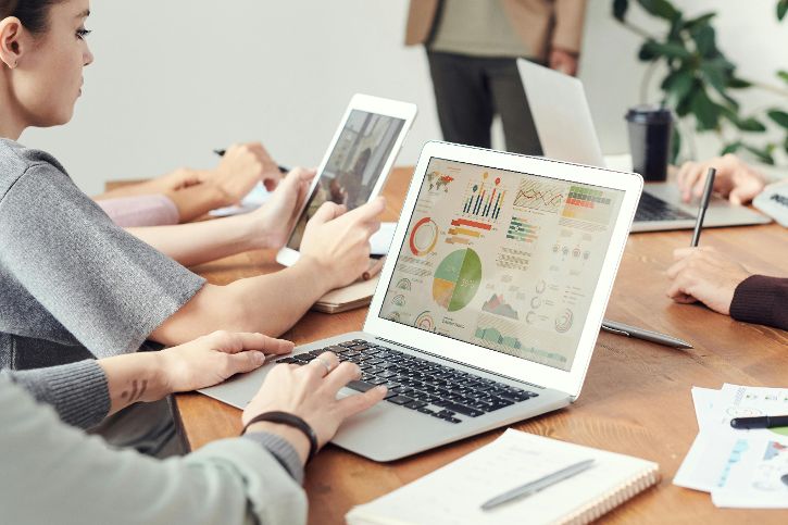 Eine Arbeitsplatzsituation, Nahaufnahme eines Tisches mit drei Laptops mit geöffneten Programmen darauf. &copy; Fauxels  - Pexels 