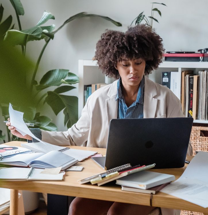 Eine Frau an einem Schreibtisch vor einem Laptop sitzend. © Mizuno  - Pexels 