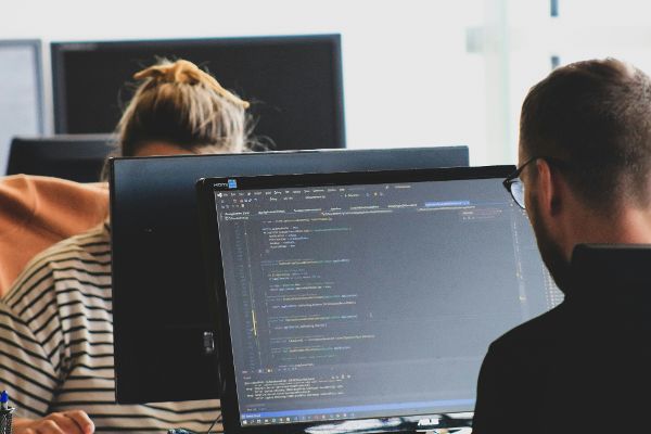 Person vor Bildschirm der programmiert