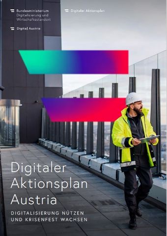 Mann mit weißem Helm und gelber Weste steht auf dem Dach eines Hochhauses und benutzt sein Tablet. Im Hintergrund sieht man die Digital Austria Flagge.