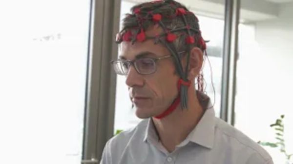 Bild zeigt Mann mit Elektrodenkappe