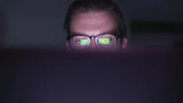 Mann, dessen untere Gesichtshälfte von einem Bildschirm verdeckt ist.