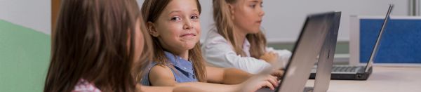 Drei Schülerinnen sitzen vor einem Laptop ©  freepik.com 