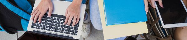 Hände auf einem Laptop und Bücher daneben ©  freepik.com 