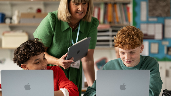 Lehrerin mit zwei Schülern vor Laptops. &copy;  Matthew Joseph 