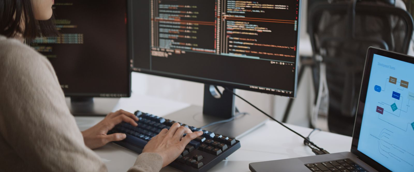 Frau sitz vor einem Bildschirm worauf Codes zu sehen sind © Urbanscape - Adobe Stock