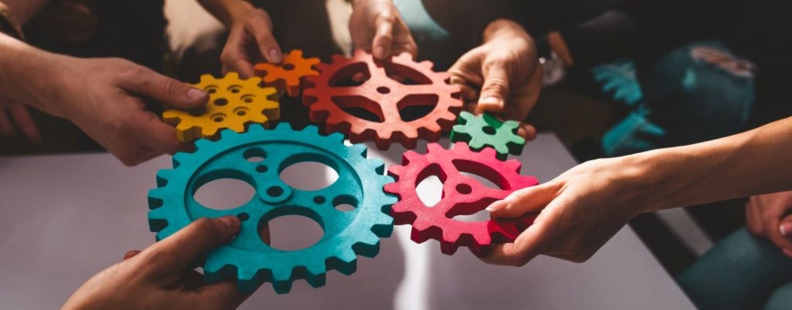 Teamwork von Geschäftsleuten, die zusammenarbeiten und Teile von Zahnrädern kombinieren © alphaspirit - AdobeStock_578038026
