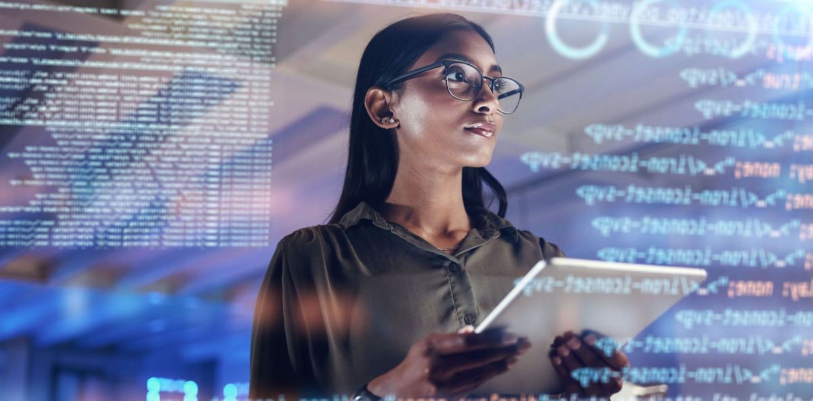 Frau steht vor transparenter Wand mit Tabellen, Texten und Grafiken angezeigt. © peopleimages.com  - AdobeStock_621254974 