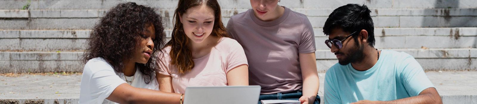 Vier teeanger sitzen gemeinsam vor einem Laptop © freepik.com