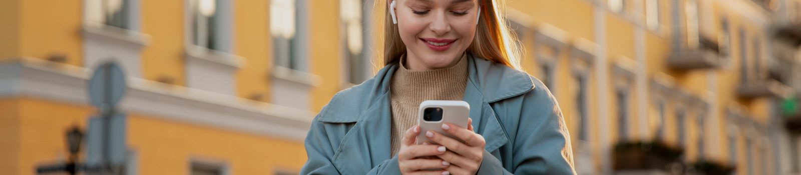 Junge Frau hält lächelnd Smartphone in der Hand © freepik.com