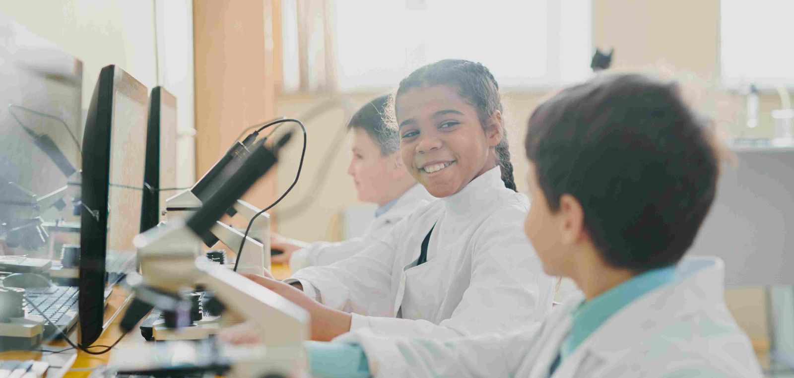 Drei Kinder in Laborkittel. &copy;  Unsplash+ 