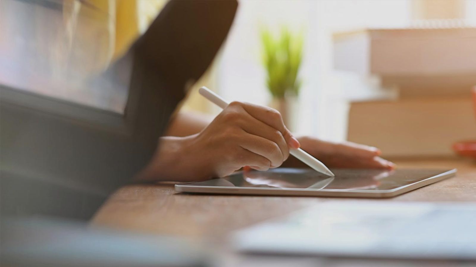 Hand zeichnet oder schreibt etwas mit Stift auf Tablet © Unsplash+