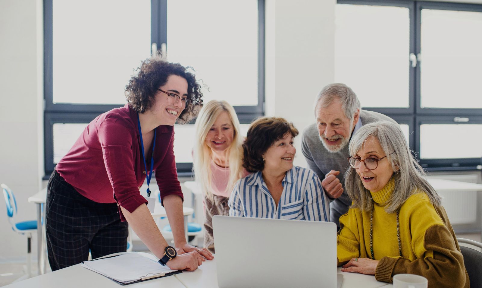 Gruppe von Personen sieht lächelnd auf einen Laptop © Unsplash+