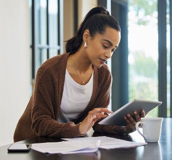 Junge Frau sitzt am Schreibtisch mit Tablet in der Hand ©  CineLens_peopleimages_com  - AdobeStock 