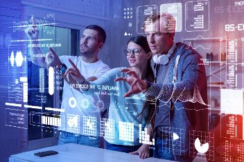 Zwei Männer und eine Frau stehen vor einer Animationswand mit Zahlen, Daten, Grafiken und Text © Viacheslav Yakobchuk  - AdobeStock 