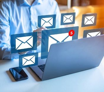 Geschäftsfrau mit Laptop und E-Mail-Benachrichtigung auf dem virtuellen Bildschirm.  © 702602060 Benoît  - Adobe Stock 
