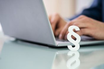 Mann sitzt vor Laptop. Im Vordergrund sieht man das Zeichen für Paragraph. © Andrey Popov  - AdobeStock 