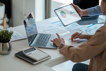 Zwei aufgeklappte Laptops auf Schreibtisch mit Unterlagen. &copy; Natee Meepian  - Adobe Stock 