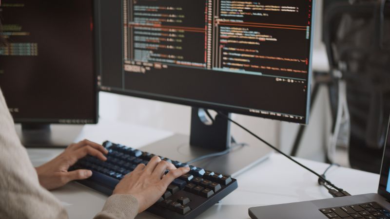 Frau sitz vor einem Bildschirm worauf Codes zu sehen sind © Urbanscape  - Adobe Stock  
