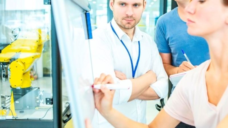  Mitarbeiter werden an dem Einsatz von Industrierobotern ausgebildet © 548470567 Alexander Limbach  - AdobeStock_ 