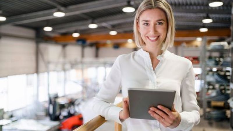 Porträt einer lächelnden jungen Frau, die ein Tablet in einer Fabrik benutzt © @AdobeStock_838984973 by tunedin  - @AdobeStock_838984973 