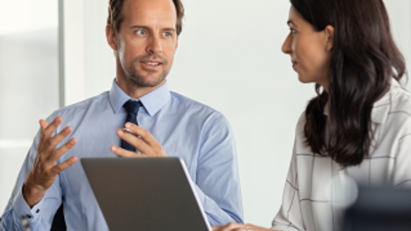 Drei Männer und eine Frau sitzen bei einem Meeting mit Laptops und diskutieren miteinander  © Rido  - AdobeStock 