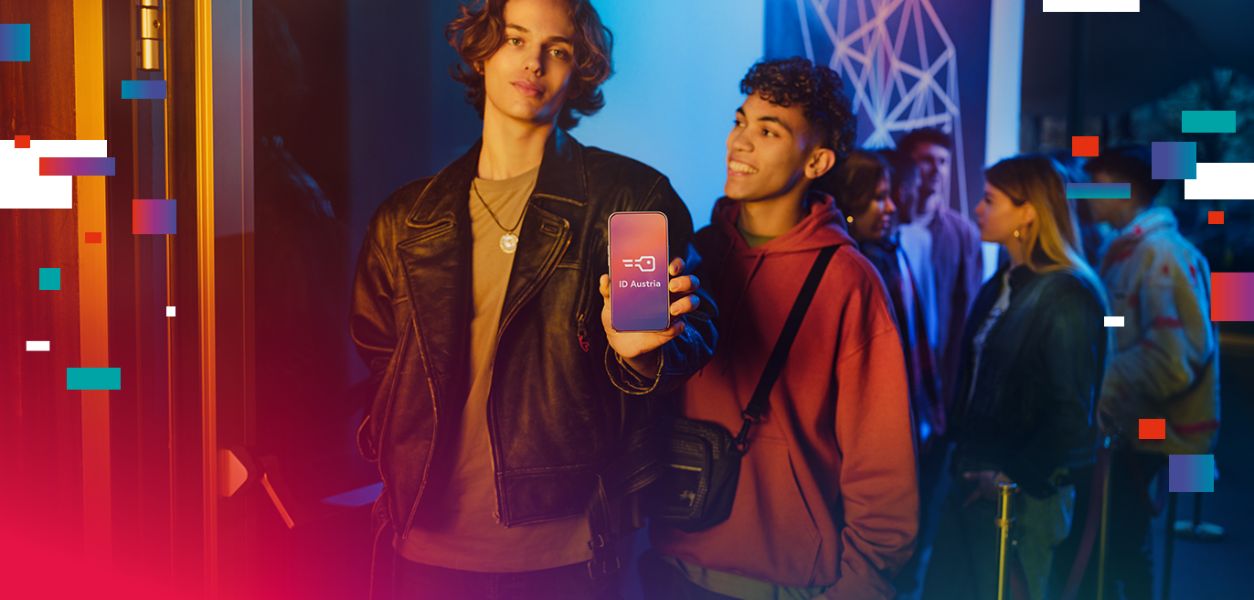 Zwei männliche Jugendliche weisen sich vor dem Club mittels Smartphone aus.