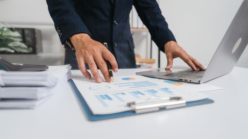 Young asian business man audit analysis graph company budget report, cash inflow, pension fund, disclosure, assigned accounts receivable, production control, operational audit, cost-plus pricing